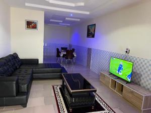 a living room with a couch and a tv at YP-Made Luxurious 1 & 2 Bedroom Apartments in Eluju