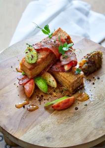 une assiette de nourriture avec du pain grillé et des fruits sur un plateau de découpe dans l'établissement One&Only Cape Town, au Cap