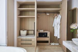 a bathroom with a walk in closet with a microwave at One&Only Cape Town in Cape Town