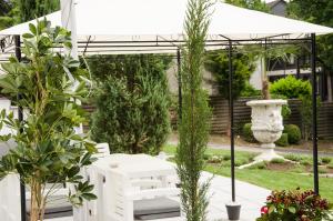 Villa Vera في ويتير: طاولة نزهة بيضاء تحت مظلة بيضاء في حديقة