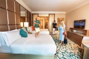 una niñita parada en una cama en una habitación de hotel en Atlantis, The Palm, en Dubái