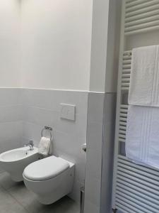 a white bathroom with a toilet and a sink at Tra borghi e mare - Ripatransone in Ripatransone