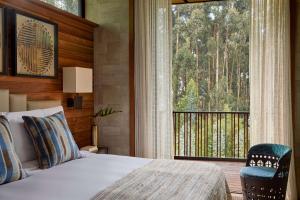 ein Schlafzimmer mit einem Bett und einem großen Fenster in der Unterkunft One&Only Gorilla's Nest in Kinigi