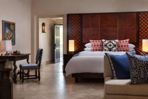 a bedroom with a bed and a desk and a chair at One&Only Palmilla in San José del Cabo