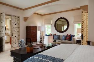 a bedroom with a bed and a couch and a mirror at One&Only Palmilla in San José del Cabo