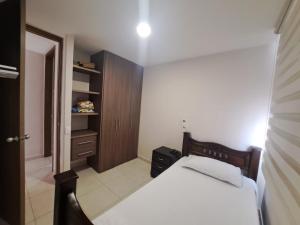a bedroom with a bed and a wooden cabinet at Torino Barranquilla- Miramar in Barranquilla