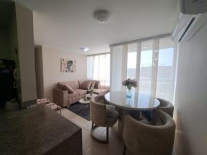 a living room with a table and chairs and a couch at Torino Barranquilla- Miramar in Barranquilla
