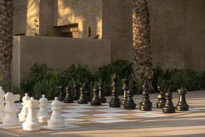 una scacchiera con scacchi giganti impostati su un cortile di Bab Al Shams, A Rare Finds Desert Resort, Dubai a Dubai