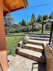 a set of stairs with a fence in the background at Cabañas Bosque Andino con hidromasaje in Esquel +1 photo