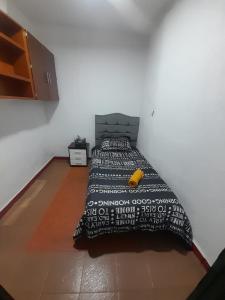- une chambre avec un lit et une couverture noire et blanche dans l'établissement HOTEL BS, à Nemocón