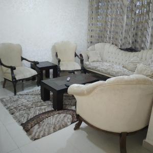 ein Wohnzimmer mit Sofas, Stühlen und einem Tisch in der Unterkunft عمان الجاردنز خلف بن العميد in Amman