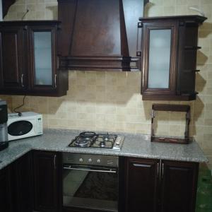 uma cozinha com um fogão e um micro-ondas em عمان الجاردنز خلف بن العميد em Amã