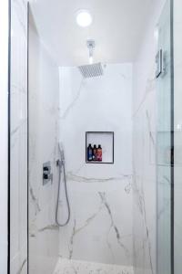 a bathroom with a shower with white marble tiles at Modern 3BR Luxury House with Jacuzzi in Los Angeles