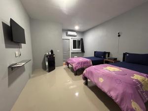 um quarto de hotel com duas camas e uma televisão em เช็คอินรีสอร์ทชัยนาท Check-in resort em Ban Khao Khayai (1)