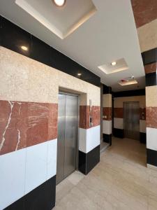a lobby with black and white walls and a elevator at دبليو تاون للشقق المخدومة - W Town Serviced Apartments in Jeddah
