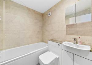 een badkamer met een toilet, een wastafel en een bad bij Stylish 2 bedroom Apartment in Kettering Town Centre, sleeps 4, free parking, wifi, Sky, Netflix in Northampton