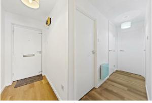 a white room with white walls and wooden floors at Stylish 2 bedroom Apartment in Kettering in Northampton