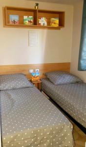 two twin beds in a room with at Mobil-home Le cocon in Canet-en-Roussillon