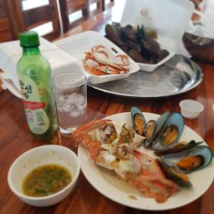a table with a plate of seafood and a bowl of soup at Pinsuk house Huahin บ้านปิ่นสุข หัวหิน ชะอำ in Phetchaburi