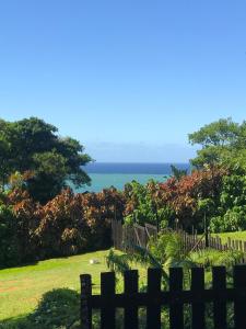 a wooden fence with the ocean in the background at Thalassa's in Port Shepstone