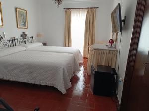 Postel nebo postele na pokoji v ubytování Hostal Gran Capitan