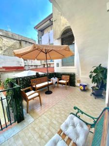 a patio with two chairs and an umbrella at Castellano apartment in Naples