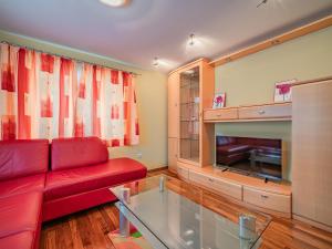 Haus Christine في نيدرمسيل: غرفة معيشة مع أريكة حمراء وطاولة زجاجية