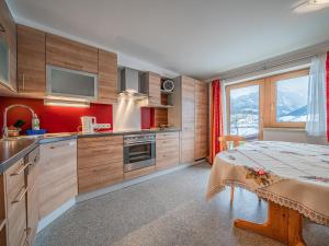 a kitchen with wooden cabinets and a bed in a room at Haus Christine in Niedernsill