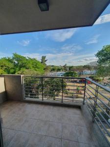een balkon met uitzicht op een rivier en bomen bij Departamento dos ambientes. in Castelar