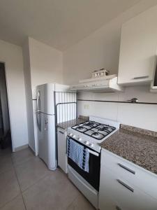 een keuken met een fornuis en een koelkast bij Departamento dos ambientes. in Castelar