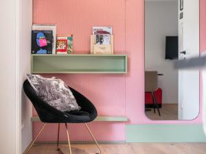 uma parede rosa com uma cadeira preta e um espelho em Lukasfeld 9 Top Erika em Hopfgarten im Brixental