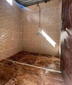 a bathroom with a shower with a tiled floor at Bedouin lifestyle in Wadi Rum