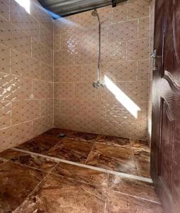 a bathroom with a shower with a tiled floor at Wadi Rum Heaven Camp in Wadi Rum +62 photos