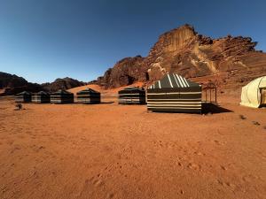 a group of tents in the desert with a mountain at Wadi Rum Heaven Camp in Wadi Rum