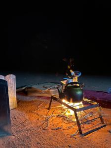 a pot sitting on top of a table with a fire at Wadi Rum Heaven Camp in Wadi Rum