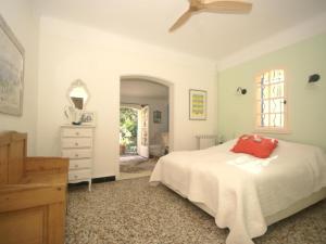 a bedroom with a bed and a dresser and a window at Les Iris in Lorgues