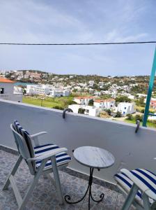 balcón con sillas, mesa y vistas en Armiriki sea view Guest home @Batsi Andros, en Batsi