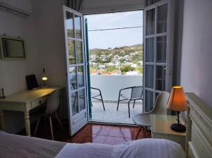 1 dormitorio con cama, escritorio y ventana en Armiriki sea view Guest home @Batsi Andros en Batsi