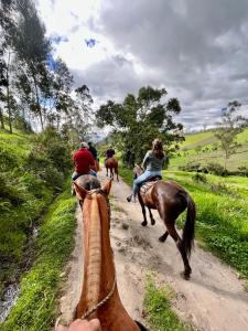 a group of people riding horses down a dirt road at Hotel El Cisne Internacional in Riobamba