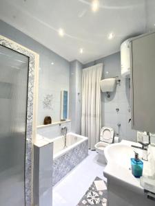 a bathroom with a tub and a toilet and a sink at Castellano apartment in Naples +107 photos