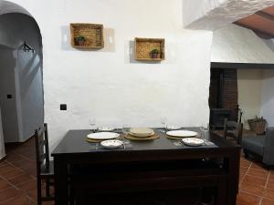 uma mesa de jantar com pratos e copos em Magnífica casa cerca del rio em Huelva