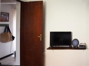 a flat screen tv sitting on a shelf next to a door at departamento en Geriba in Búzios