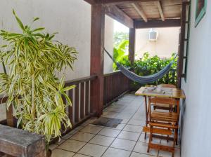 a hammock on a balcony with a table and a plant at departamento en Geriba in Búzios