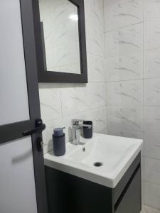 a bathroom with a white sink and a mirror at RESIDENCE TERANGA in Kammba