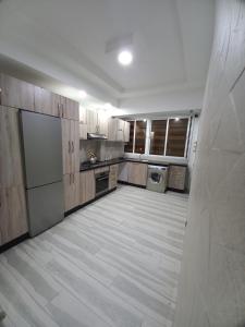 a large kitchen with wooden cabinets and a washer and dryer at Dari A10 in Agadir