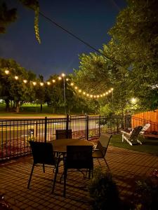 a patio with a table and chairs and lights at Campus Cottage Kng Bed! Walk To Uco And Downtown in Edmond