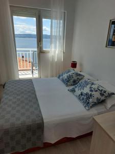1 dormitorio con 1 cama y vistas al océano en Apartments with a parking space Pisak, Omis - 1009, en Pisak