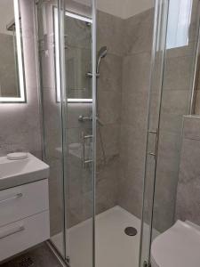 y baño con ducha y puerta de cristal. en Apartments with a parking space Pisak, Omis - 1009, en Pisak