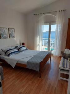 1 dormitorio con 1 cama y vistas al océano en Apartments with a parking space Pisak, Omis - 1009, en Pisak
