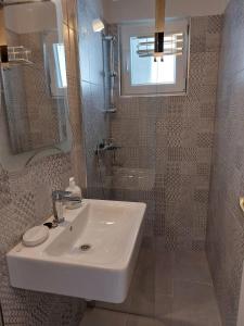 y baño con lavabo y ducha con espejo. en Apartments with a parking space Pisak, Omis - 1009, en Pisak